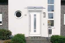 Eingangstür mit großem Aluminiumgriff und Glasfenster