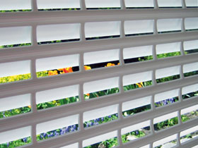 Blick durch ein Fenster mit Rollladen - Sonnenschutz & Einbruchschutz