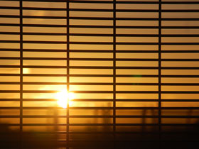 Sonnenuntergang durch Fenster mit Sonnenschutz / Hitzeschutz Jalousien von KFS Bauelemente